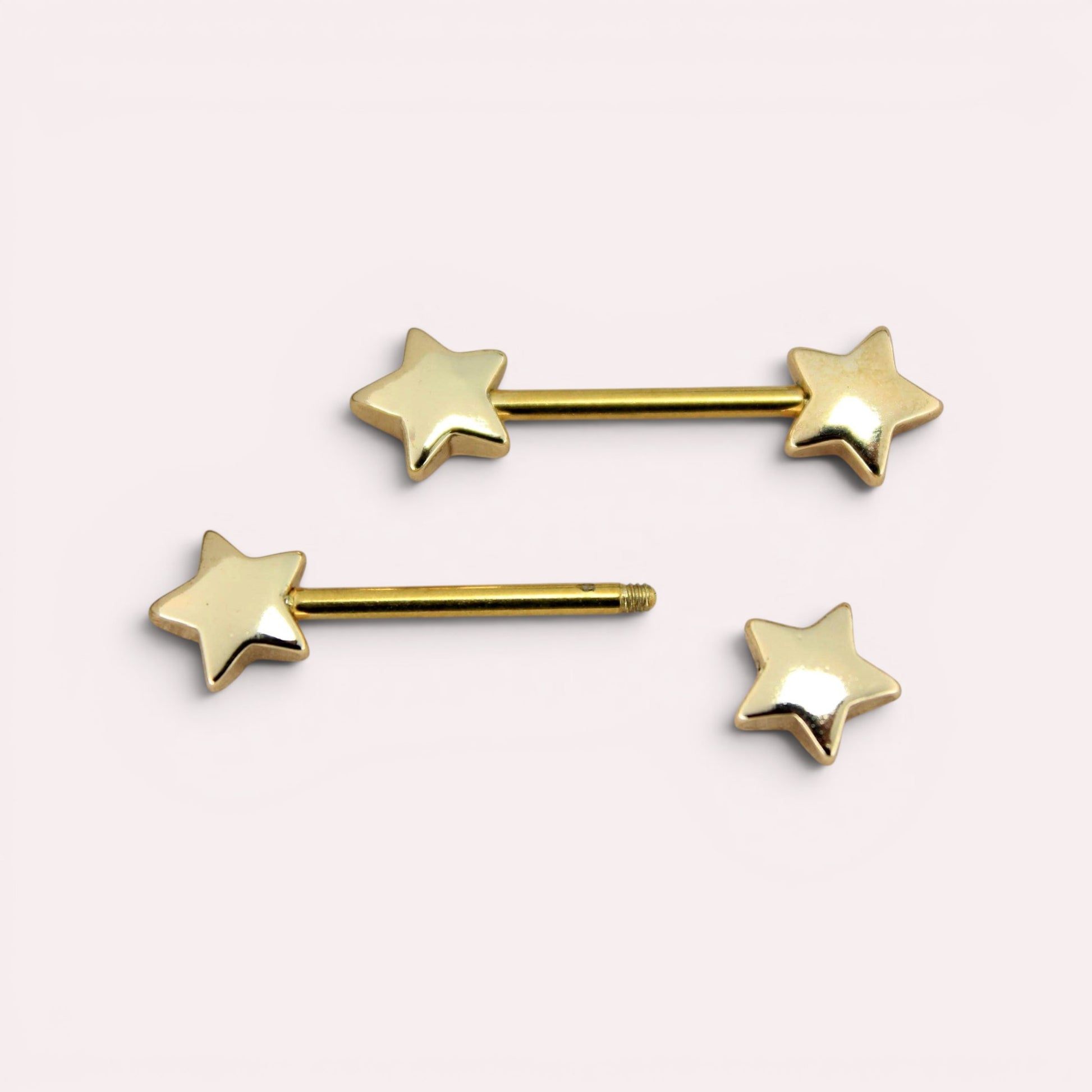 MKBodyJewelry 14G gold star nipple barbells made of hypoallergenic surgical steel, sold as a pair.
