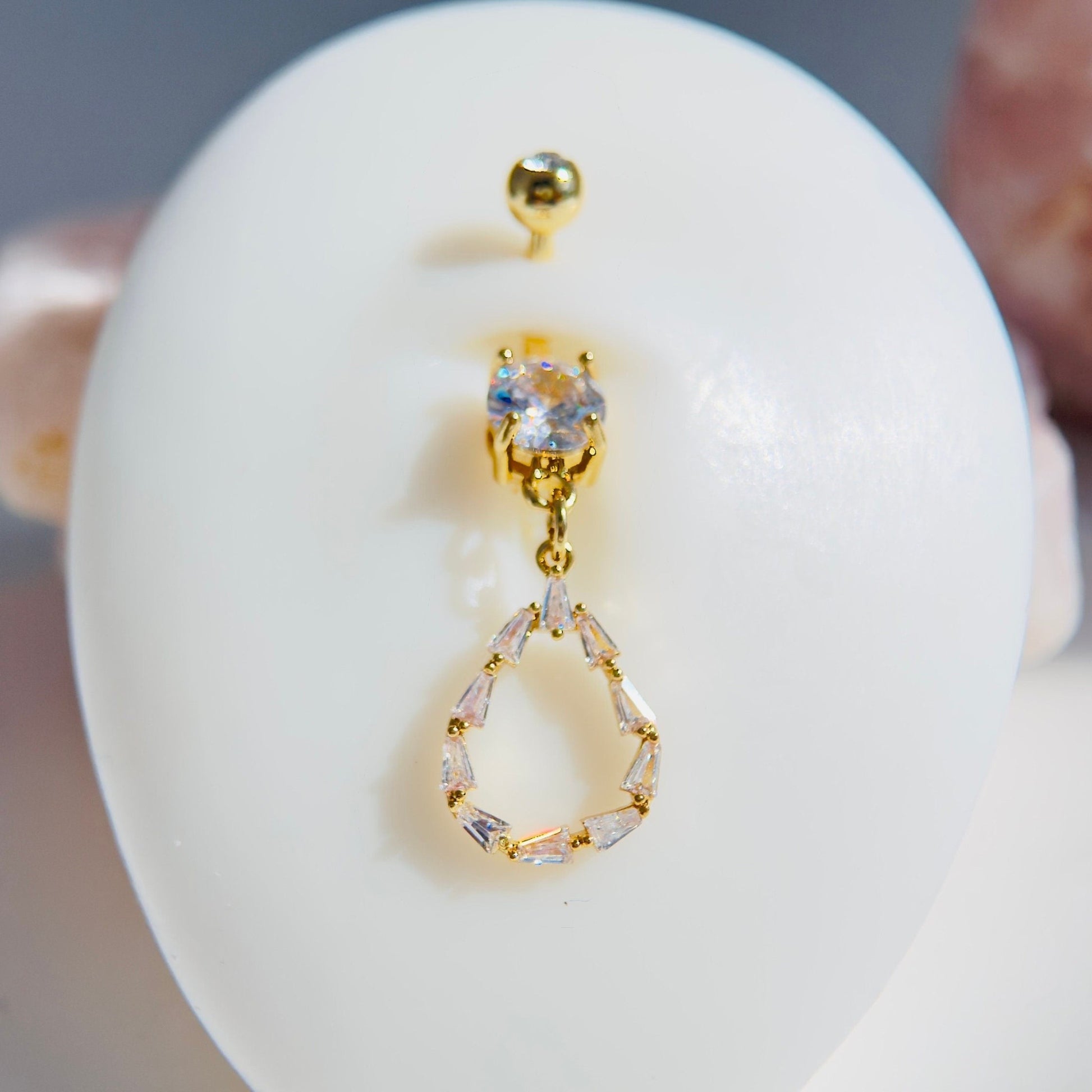 MKBodyJewelry 14G gold dangling belly button ring with a dainty baguette CZ teardrop charm on surgical steel