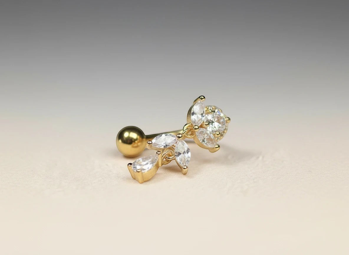MKBodyJewelry gold titanium inverted floral belly button ring with CZ stones and a dangling charm.
