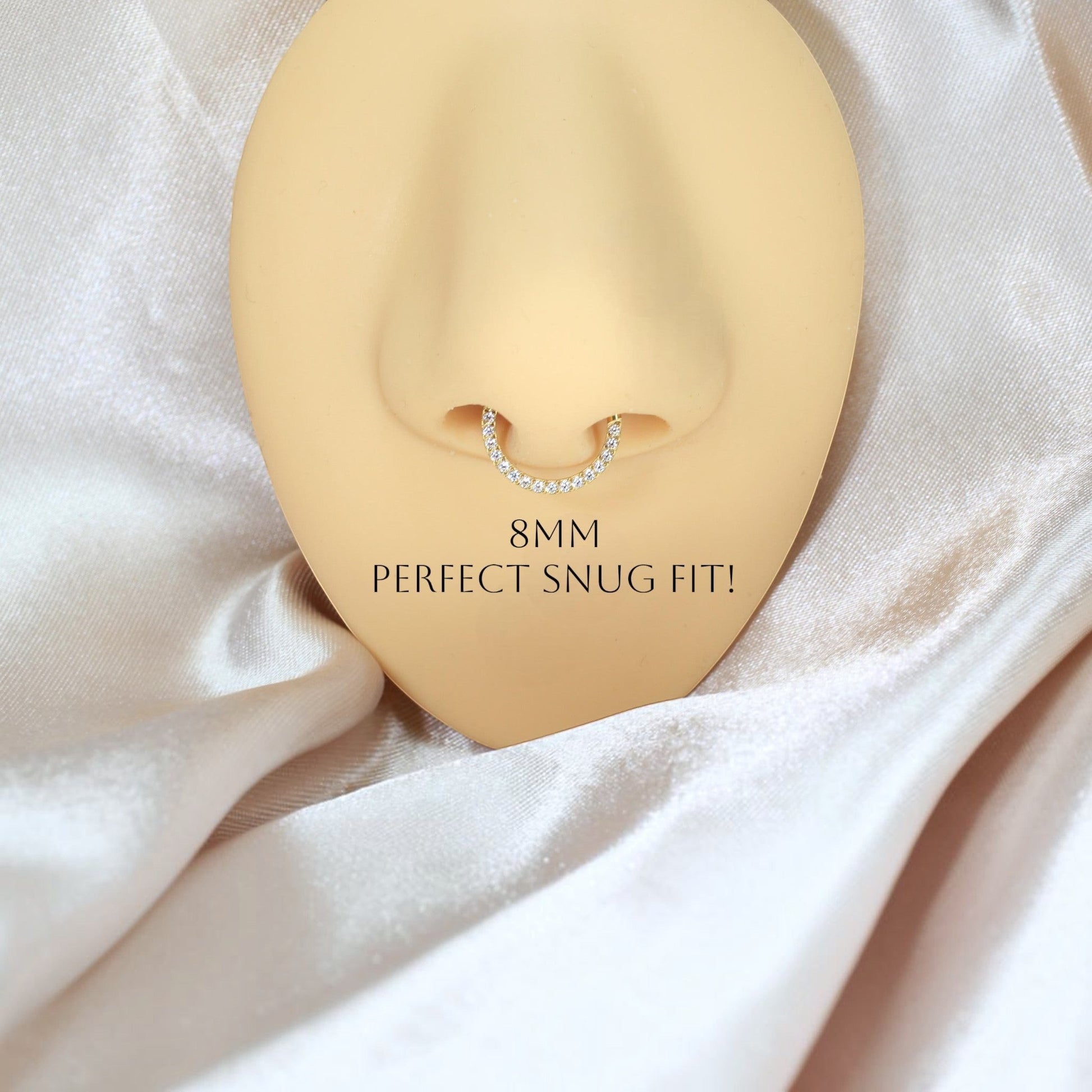 MKBodyJewelry 16G gold titanium septum clicker ring with dainty gems on a nose mannequin for a snug fit.