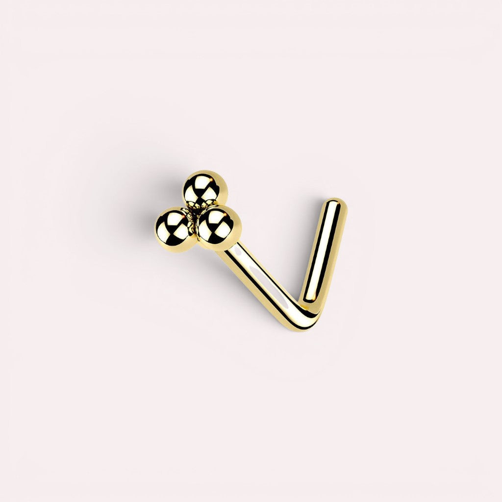 MKBodyJewelry gold L-shaped nose stud featuring a minimalist cluster of three polished spheres for a chic look.