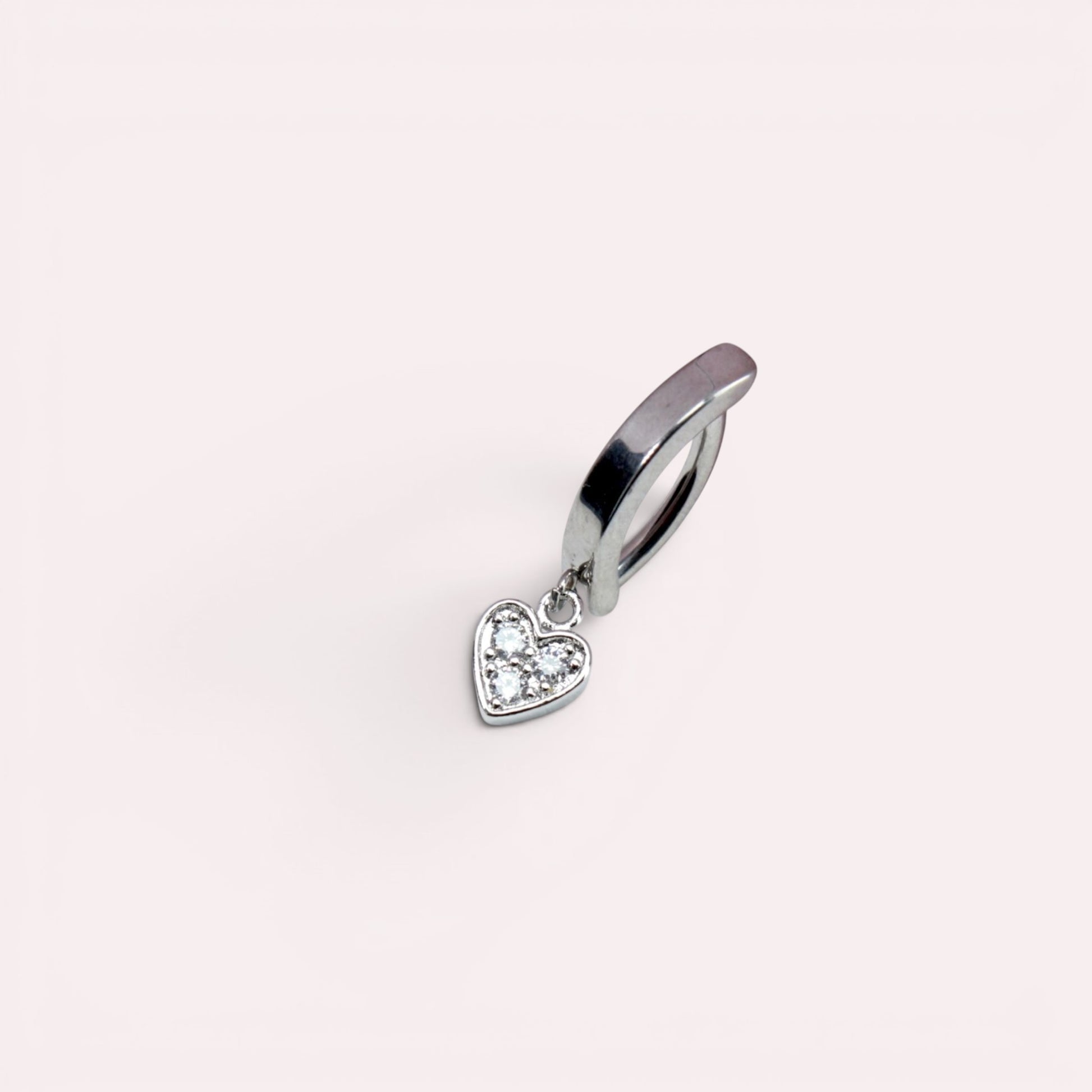 MKBodyJewelry 14g surgical steel dangling heart belly button ring with clear stones on a light background.