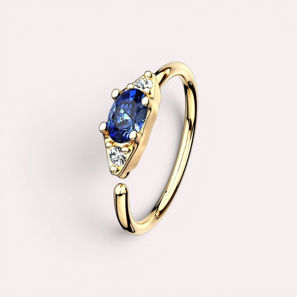 MKBodyJewelry 20g gold nose hoop ring with oval blue gem and two small clear gems. Bendable for nose or cartilage.