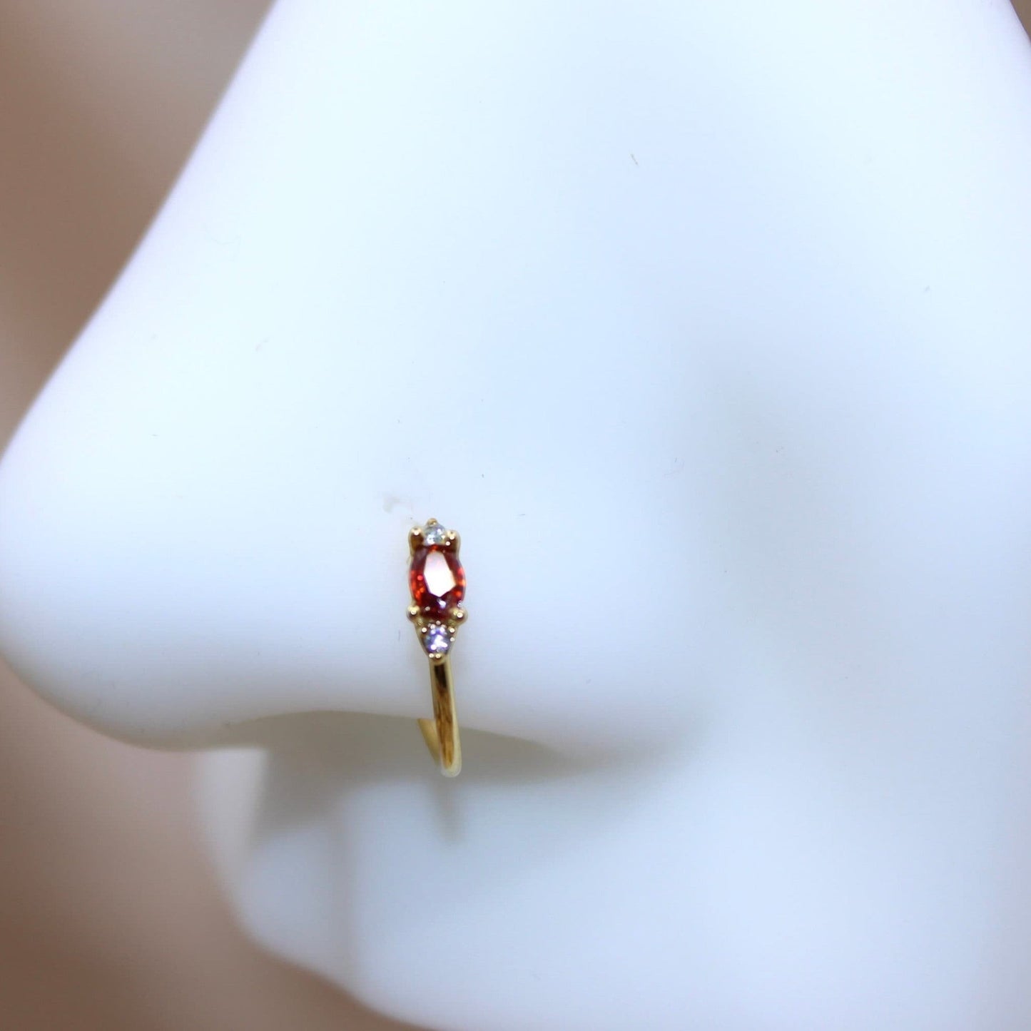 MKBodyJewelry 20g gold nose hoop ring with red oval gem and small clear gems. Bendable for nose or cartilage.