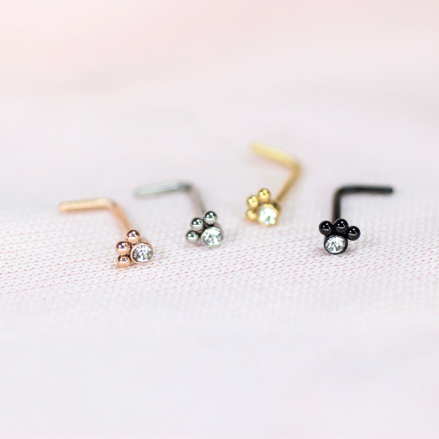 MKBodyJewelry 20G stainless steel L-shape nose studs featuring dainty paw print designs with clear crystal accents