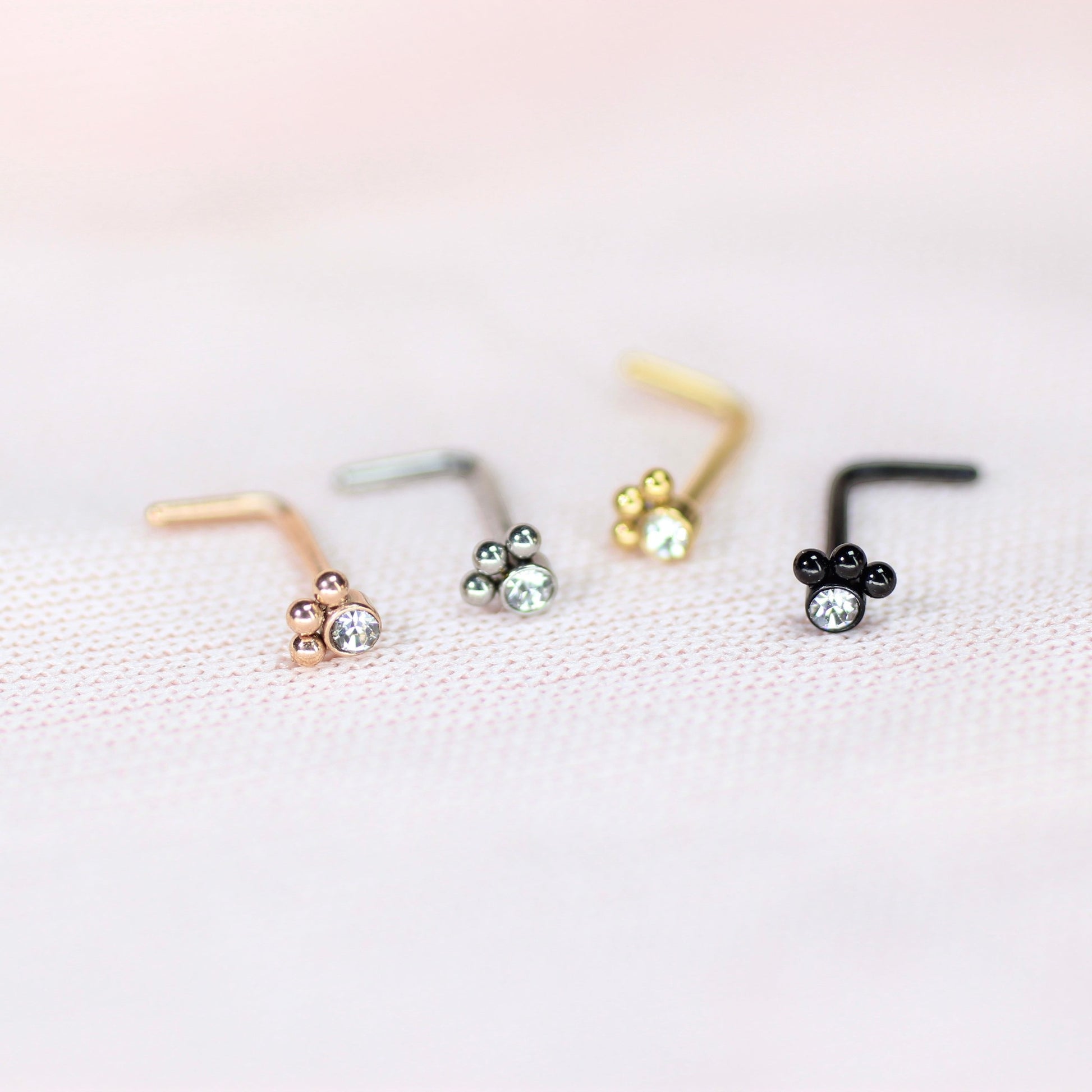 MKBodyJewelry 20G stainless steel L-shape nose studs featuring dainty paw print designs with clear crystal accents