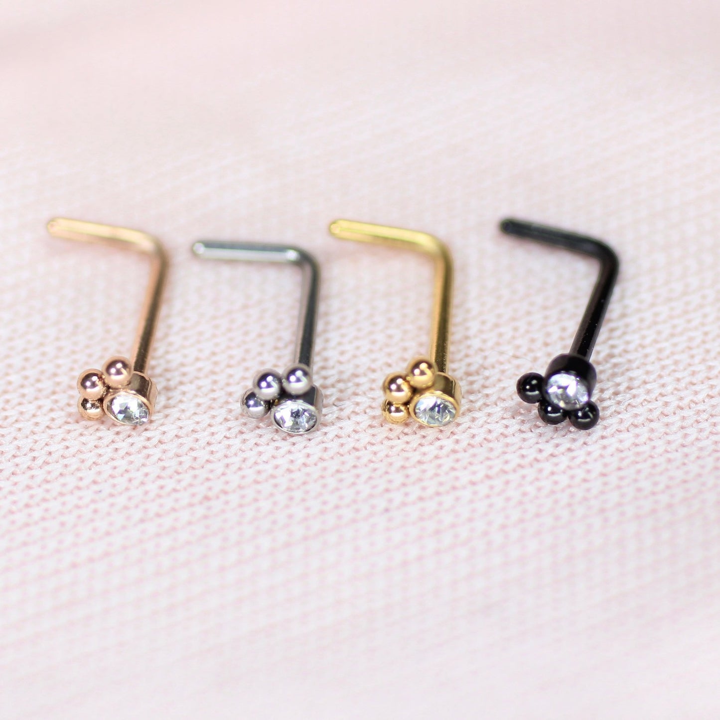 MKBodyJewelry 20G stainless steel L-shape nose studs with dainty paw print designs in gold, silver, rose, and black.