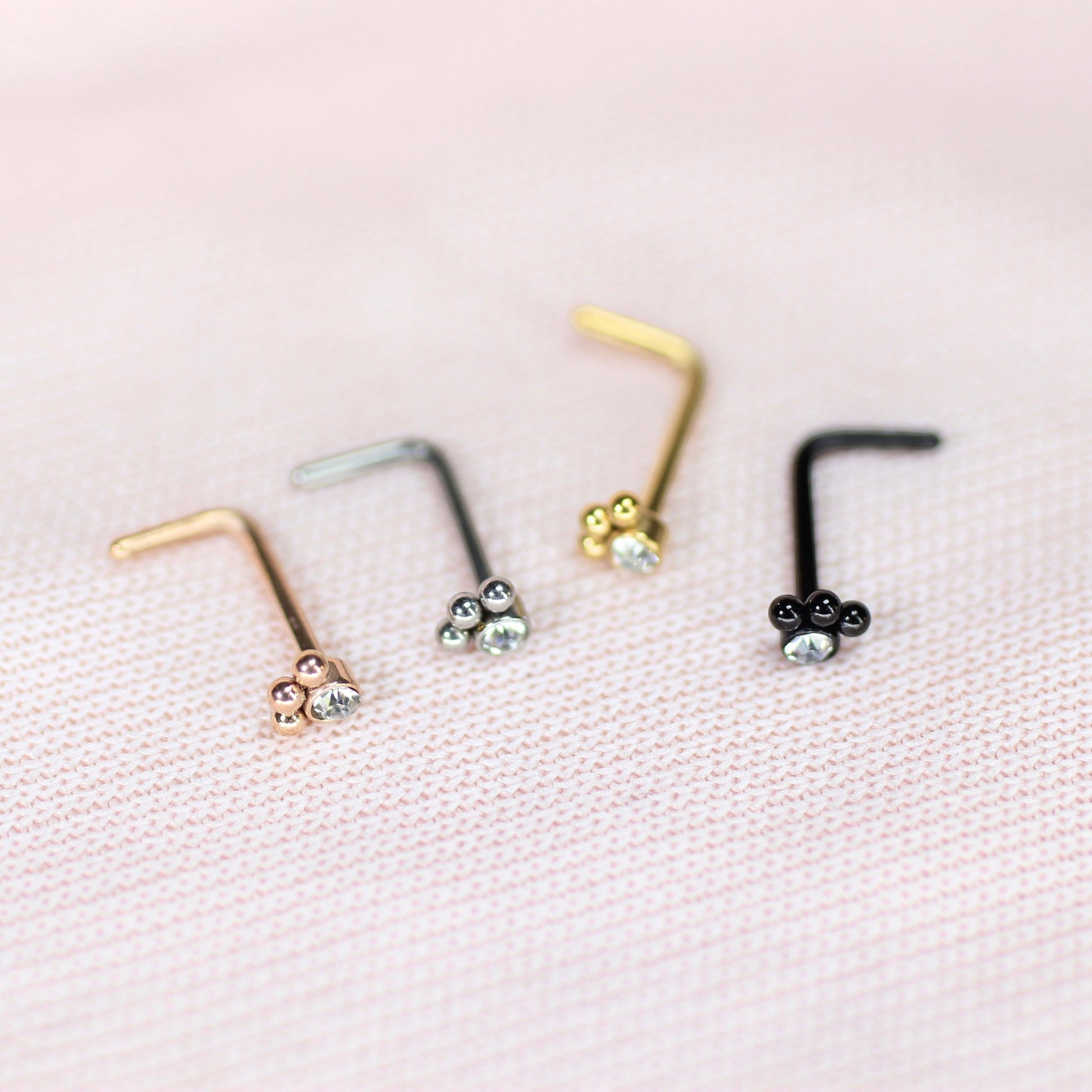MKBodyJewelry 20G stainless steel L-shape nose studs with dainty paw print designs in gold, silver, rose gold, and black.