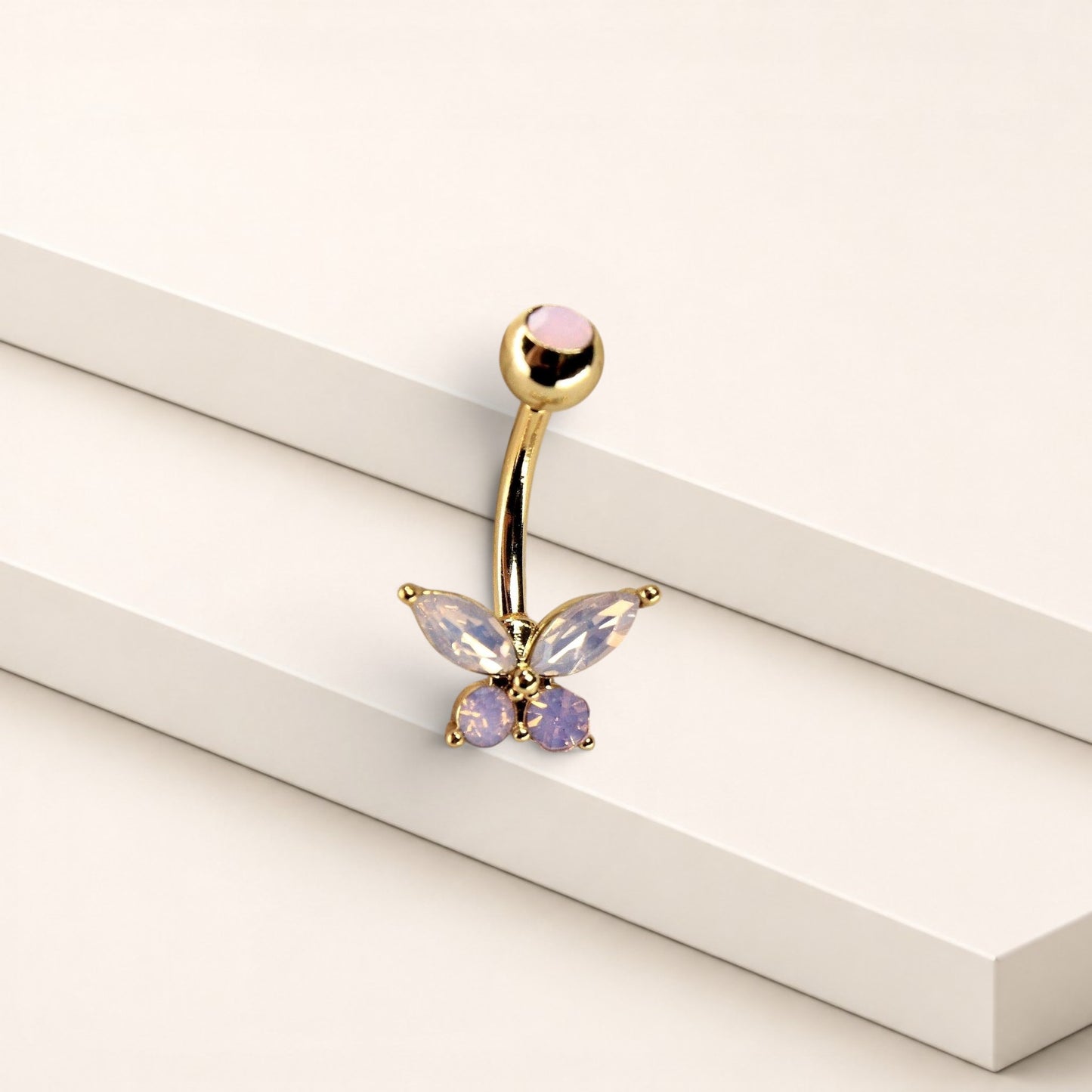 MKBodyJewelry pink butterfly belly ring in surgical steel with sparkling CZ stones on a minimalist white display
