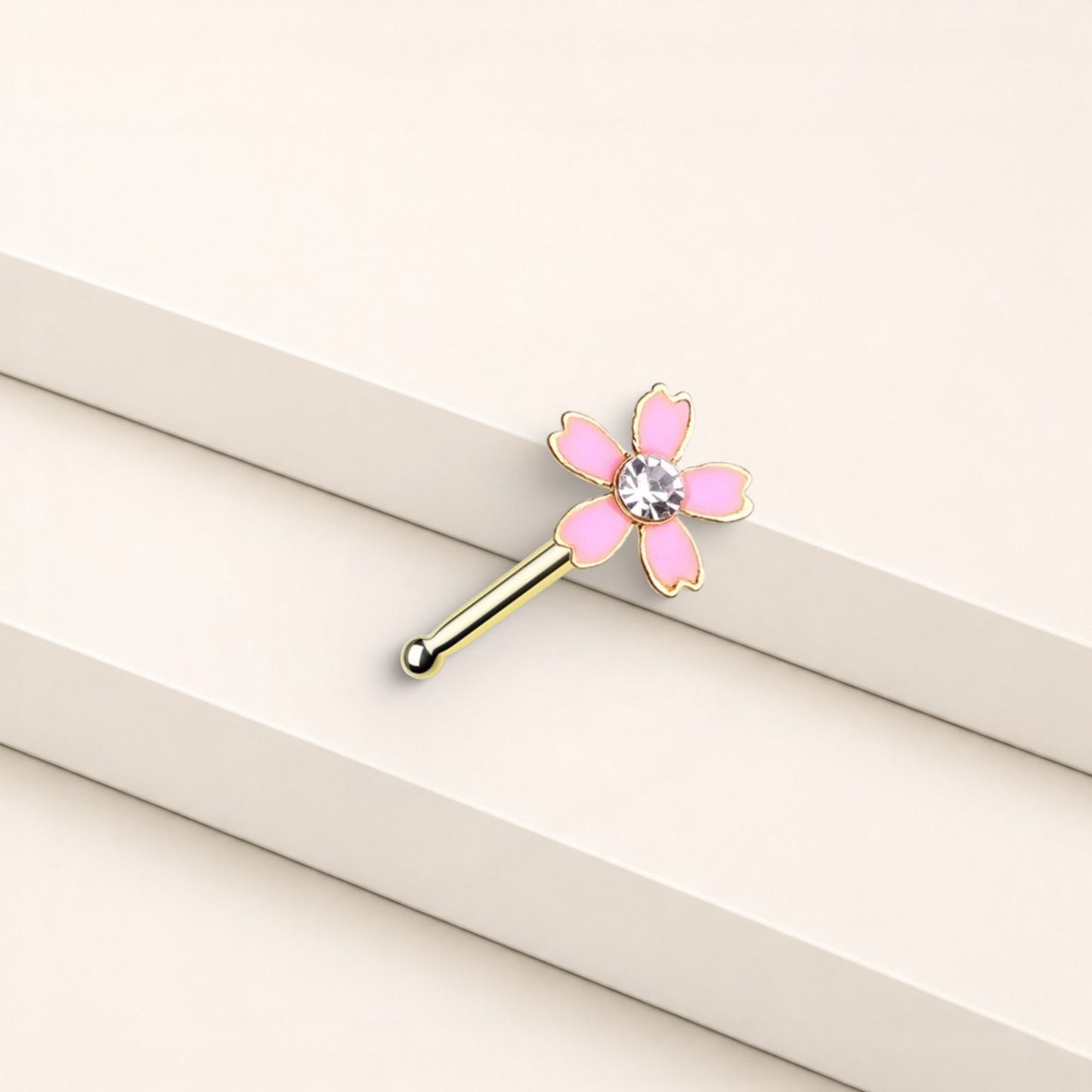 MKBodyJewelry 20G pink flower nose bone stud in surgical steel with a central crystal gem on a white background.
