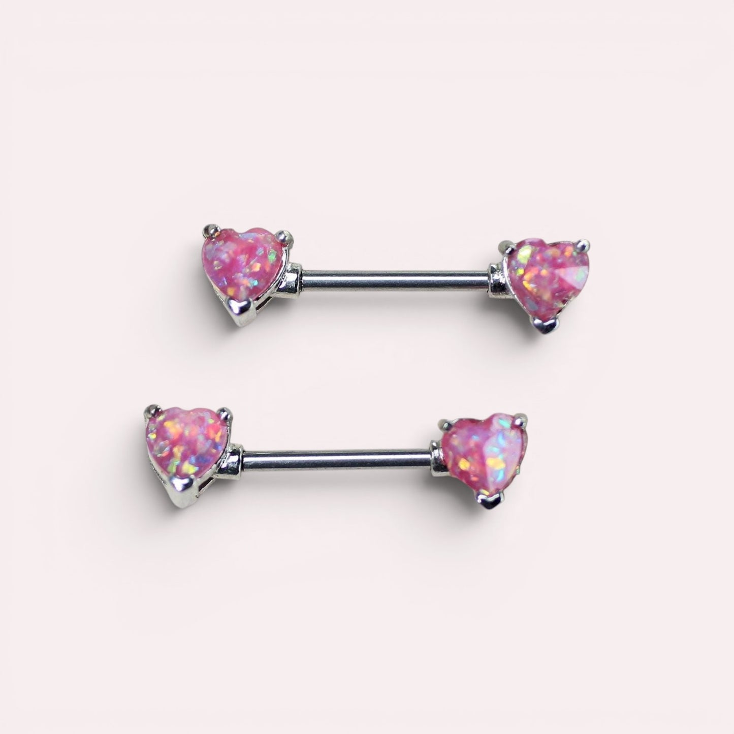 MKBodyJewelry pair of 14g surgical steel nipple barbells featuring pink glitter opal heart ends.