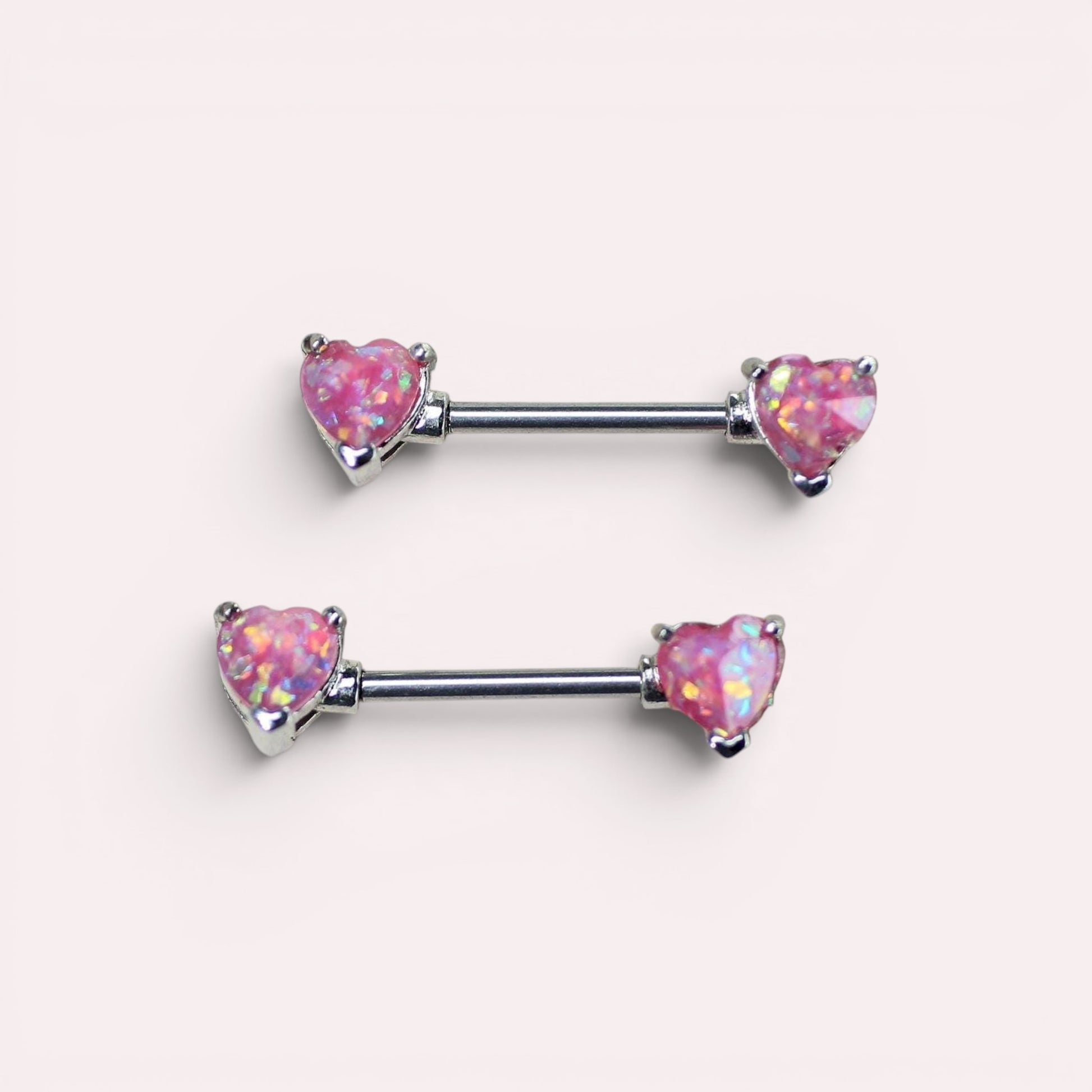 MKBodyJewelry pair of 14g surgical steel nipple barbells featuring pink glitter opal heart ends.