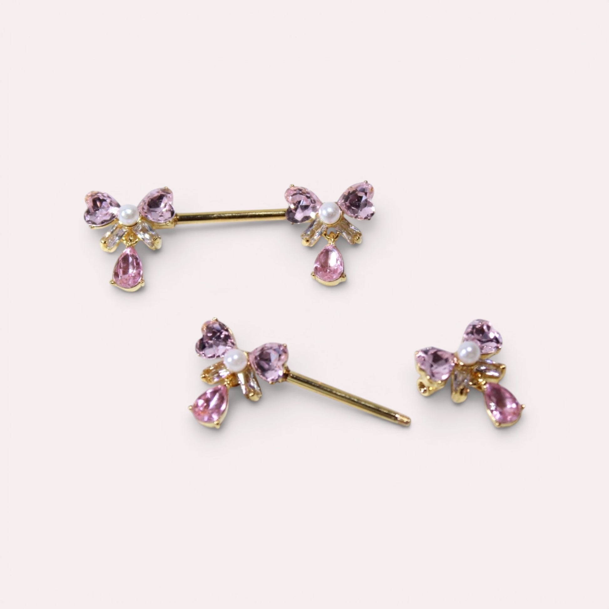 MKBodyJewelry dainty pink ribbon bow nipple rings with teardrop gems and pearl accents. Surgical steel.
