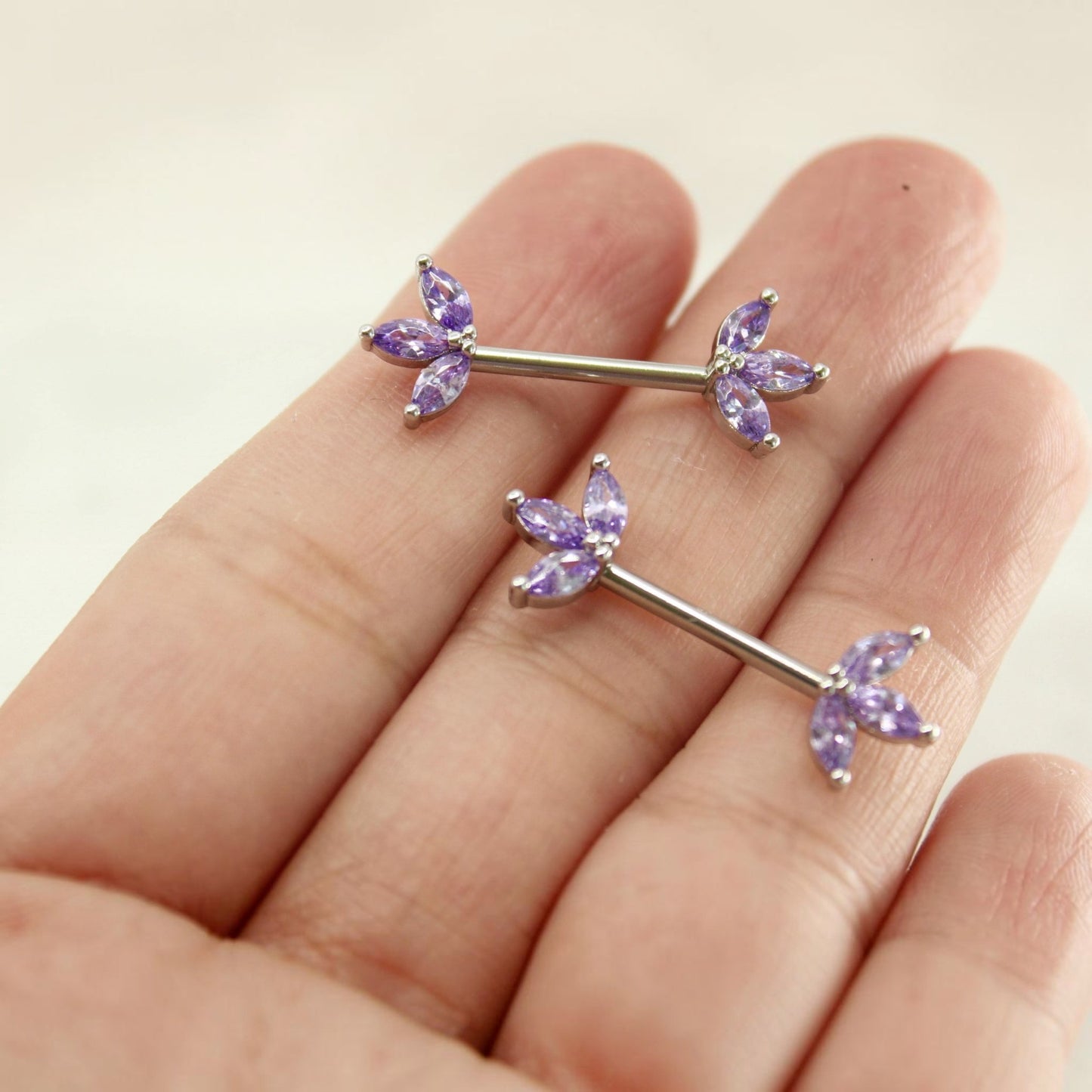 MKBodyJewelry 14G surgical steel nipple barbell pair featuring purple marquise lotus leaf floral crystal gems.