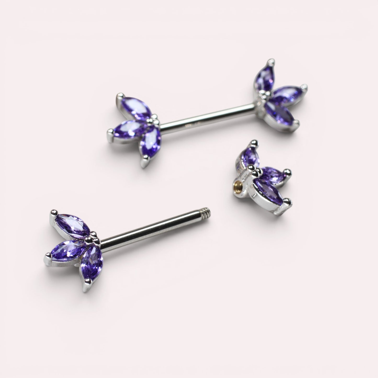 MKBodyJewelry 14G surgical steel nipple barbells featuring purple marquise-cut lotus leaf floral gem accents.