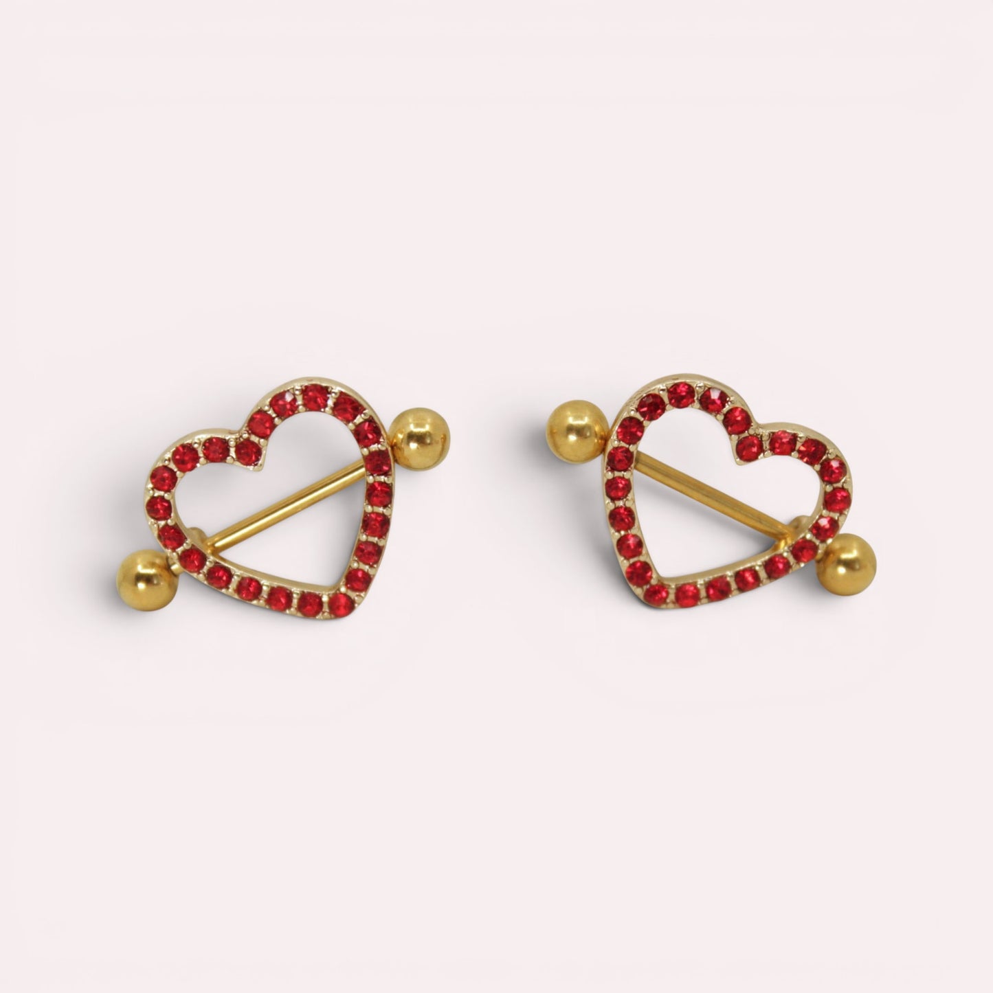 MKBodyJewelry gold surgical steel nipple barbells with red heart-shaped shields paved with sparkling red gems.