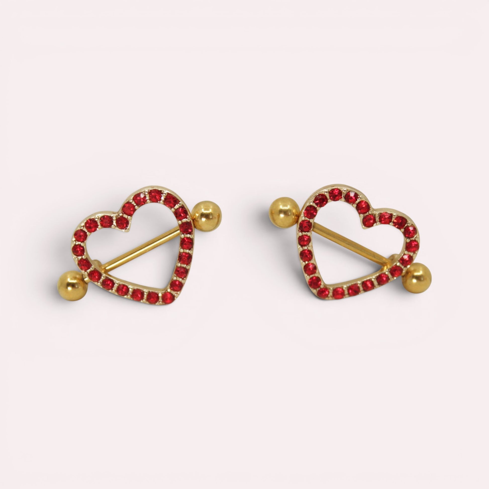 MKBodyJewelry gold surgical steel nipple barbells with red heart-shaped shields paved with sparkling red gems.