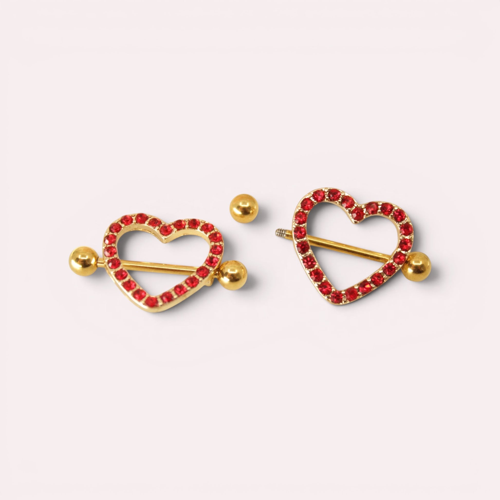 MKBodyJewelry 14g gold surgical steel nipple barbells with red heart-shaped shields paved with sparkling red gemstones.