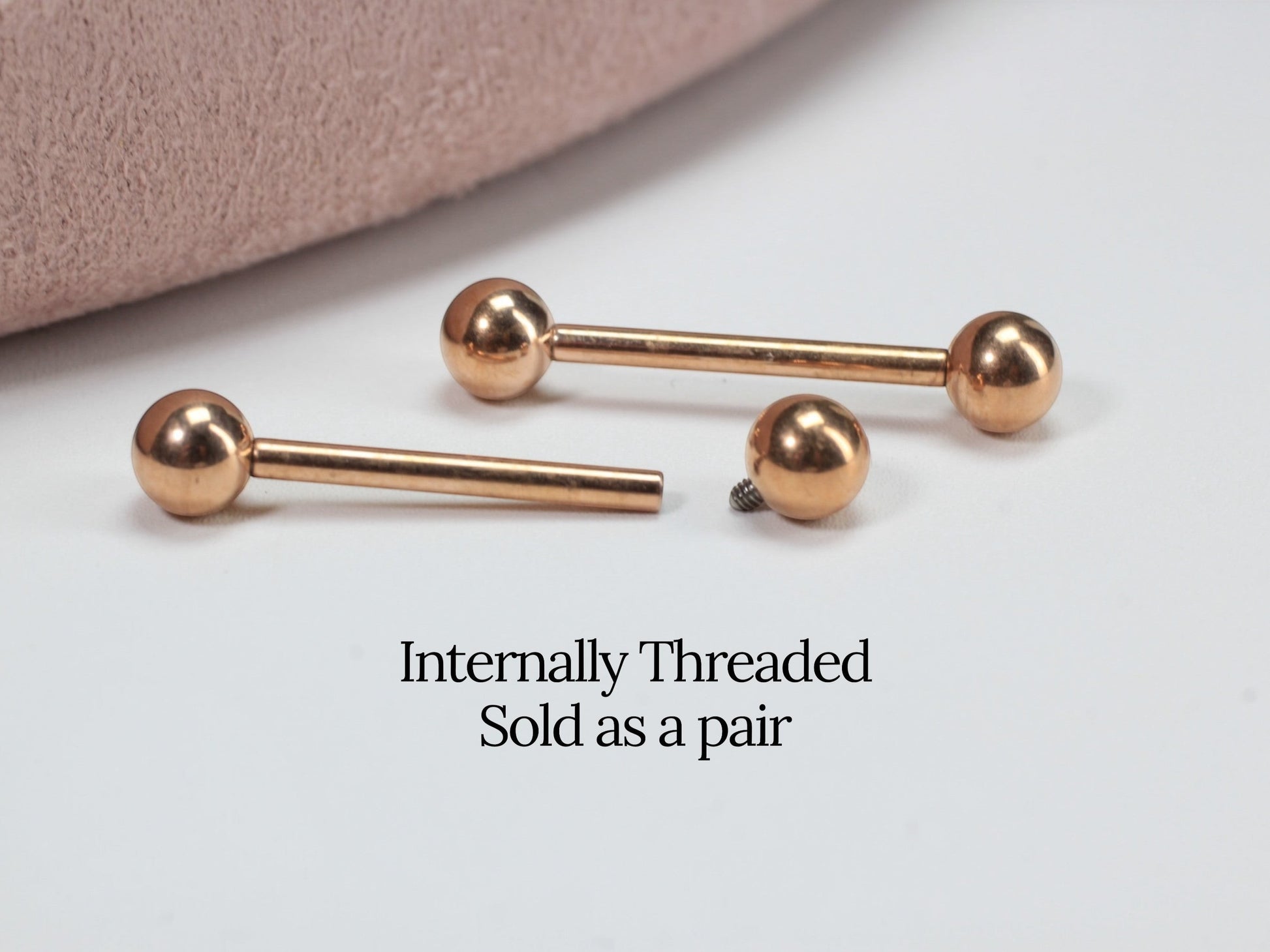 MKBodyJewelry rose gold titanium 14g internally threaded nipple barbell with smooth ball ends. Sold as a pair.