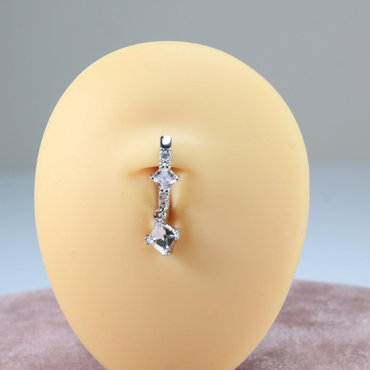 MKBodyJewelry 14g silver belly button ring with sparkling CZ stones and a dangling charm.