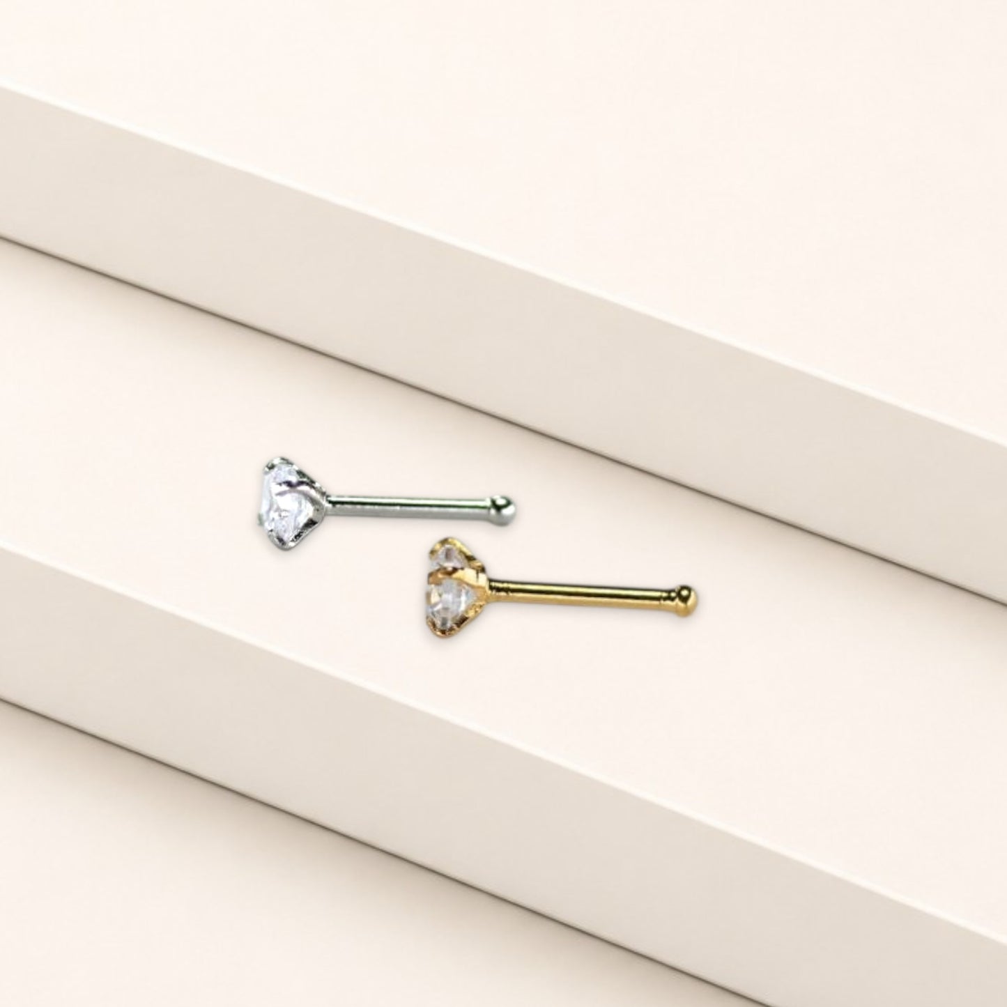 MKBodyJewelry silver-tone nose stud with a round-cut cubic zirconia stone in a four-prong setting on a white surface.