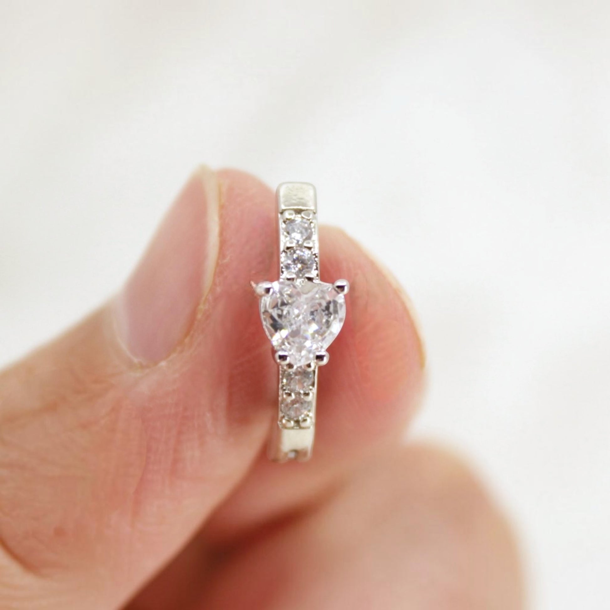 MKBodyJewelry 14G silver surgical steel belly clicker ring with a heart-shaped CZ crystal and paved accents.
