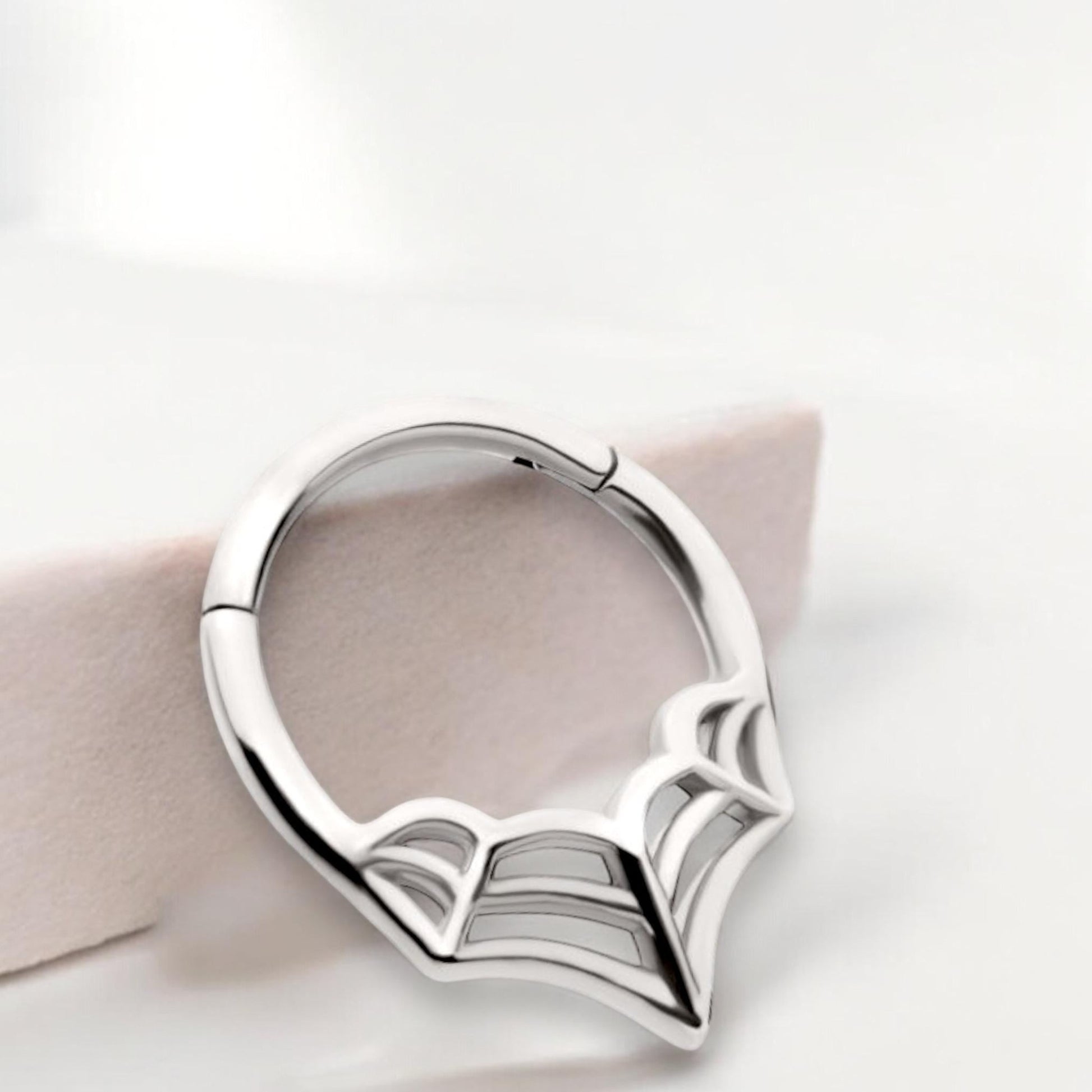 MKBodyJewelry 16G silver surgical steel septum clicker ring featuring a minimalist spider web design.