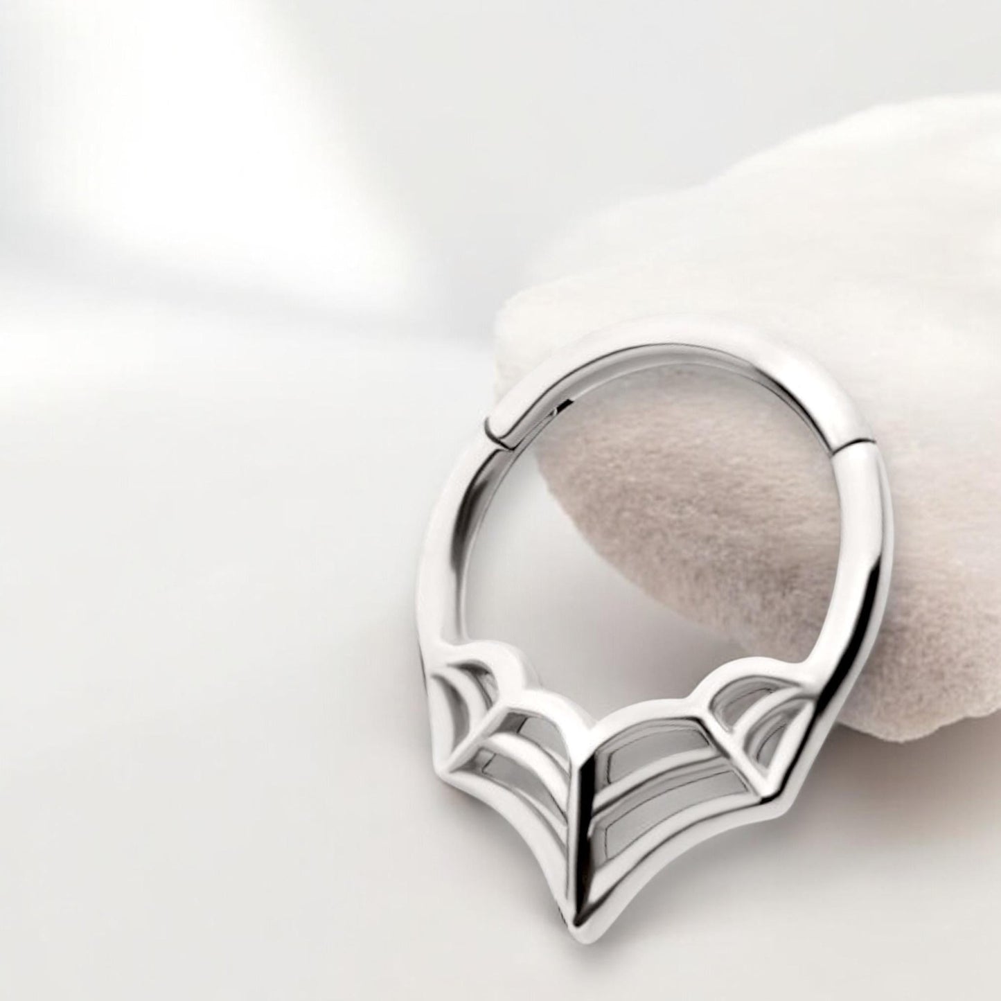 MKBodyJewelry 16G silver surgical steel spider web septum clicker ring with a hinged segment design.