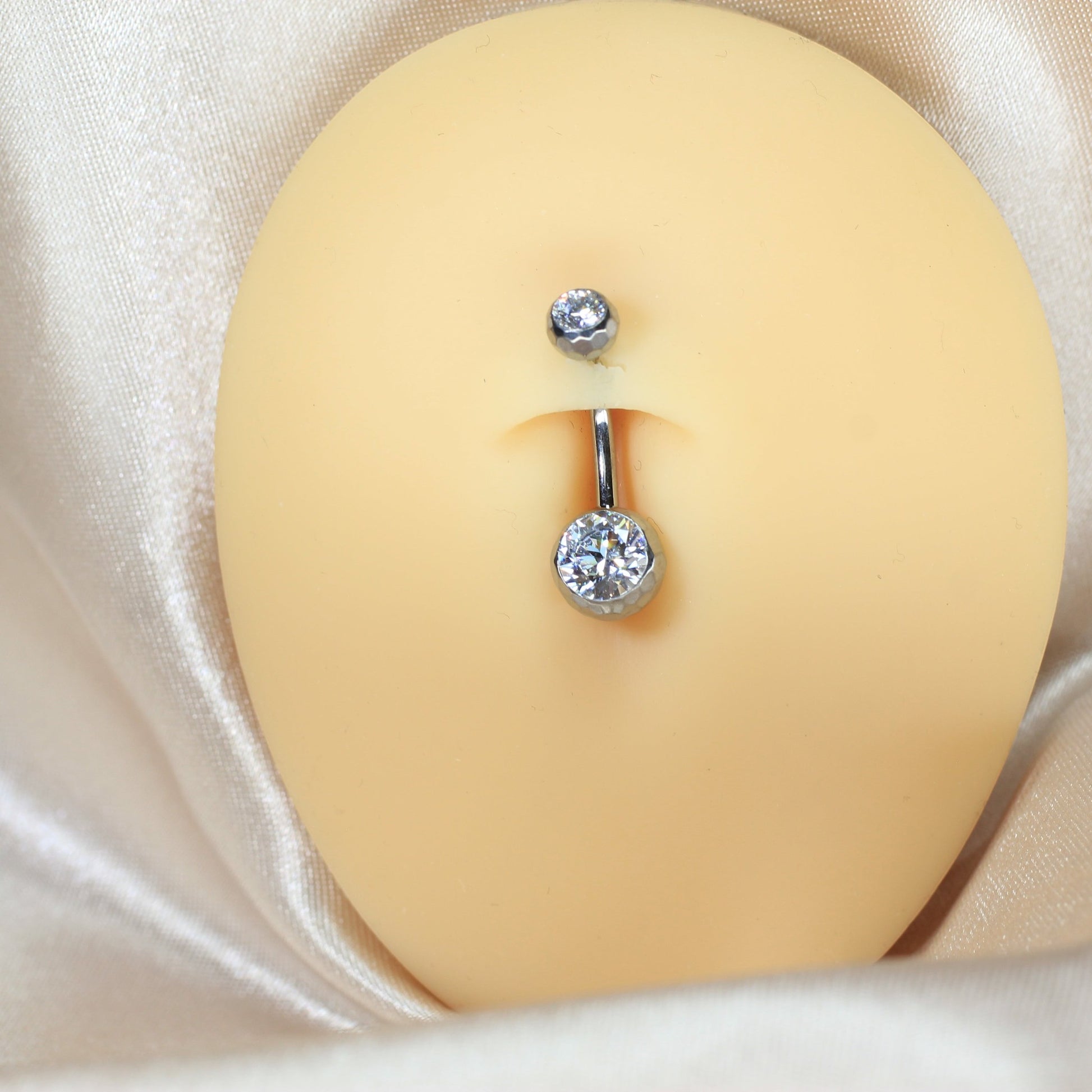 MKBodyJewelry 14g titanium belly button ring with a faceted CZ stone in a honeycomb setting on a navel model