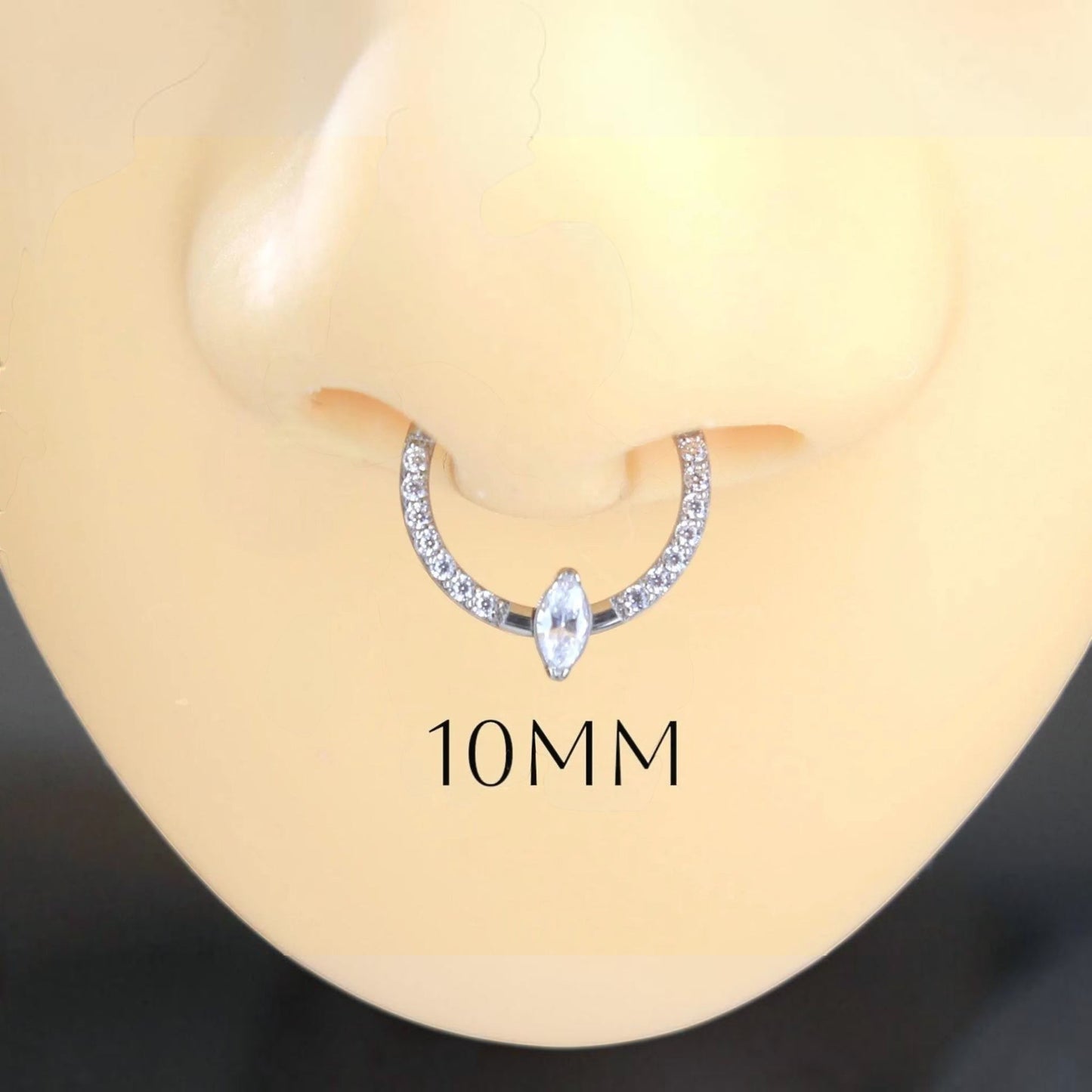 MKBodyJewelry 16g titanium septum clicker ring with a central marquise gem and pavé stones on a mannequin nose