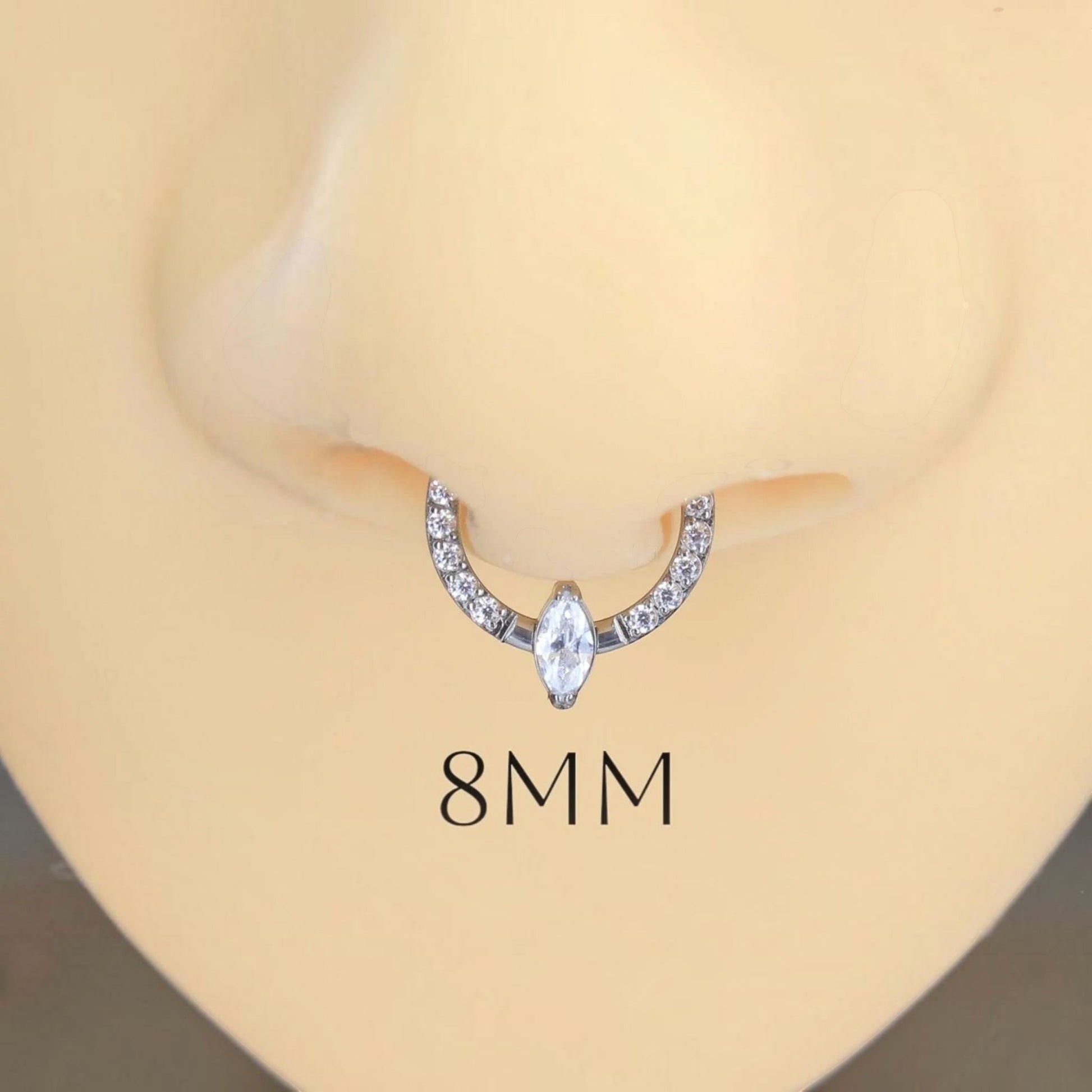 MKBodyJewelry 16g titanium septum clicker ring with a central marquise cut gem and pave stones on a nose model